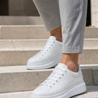 Men wearing all-white platform sneakers on stone steps