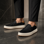 Men wearing black perforated loafers in a luxury interior