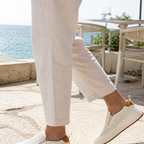 Men wearing white perforated loafers at a seaside cafe