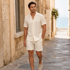 Men wearing beige textured camp shirt and shorts set in a coastal town